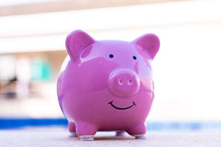 Piggy bank with smiley face on blue background, closeupの写真素材