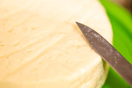 Cheese composition, close-up of a piece of cheese with a knifeの写真素材