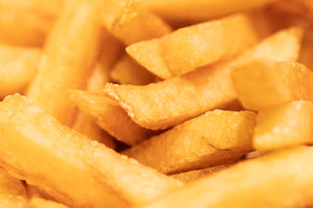 Golden French fries potatoes background. Close-up. Selective focus.
