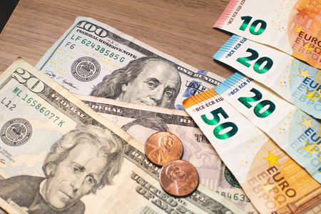 Euro and dollars banknotes and coins on a wooden table. Business conceptの写真素材