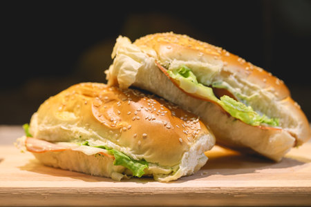 Sandwiches with ham, cheese and lettuce on a wooden boardの写真素材