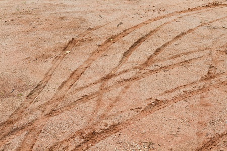 tire tracks deep in mud, dry dirt, and dust running at a angleの写真素材