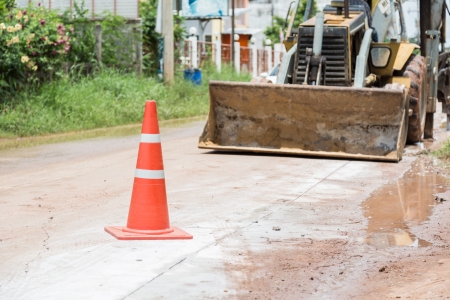 bulldozer performing road construction with orange cones.の写真素材