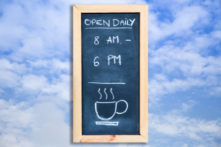 open daily on chalkboard with the skyの写真素材