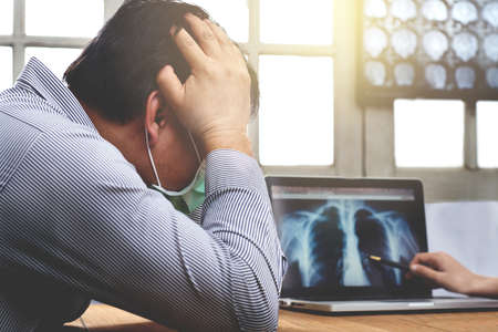 asian adult man feeling sadness and thinking on the wooden table in the hospital
