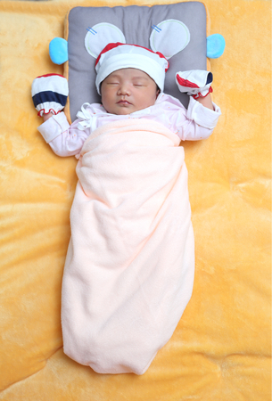 sweet dream new born sleeping on her bedの写真素材