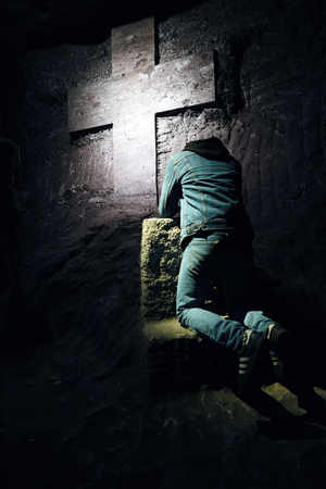 young man praying in a cathedralの写真素材