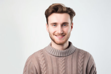 Portrait of a handsome young man smiling at camera over white backgroundの素材