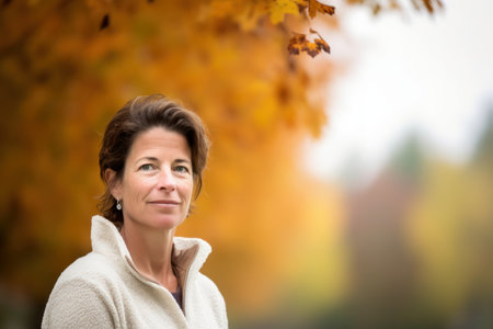 Portrait of a mature woman in an autumn park. Selective focus.の素材