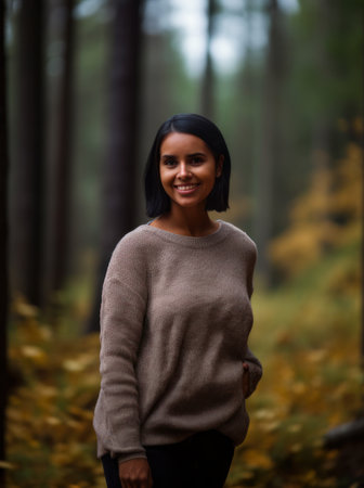 Portrait of a beautiful young woman smiling in the autumn forest.の素材