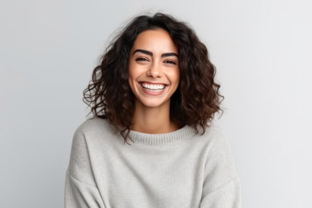 Portrait of a happy young woman smiling at camera isolated over white backgroundの素材