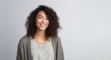 Portrait of beautiful young woman with curly hair smiling at camera.の素材