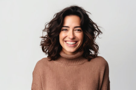 Portrait of a smiling young woman in sweater looking at camera isolated over white backgroundの素材