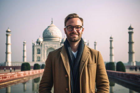 Portrait of handsome young man in front of Taj Mahal in Agra, Indiaの素材