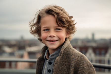 Foto per Portrait of a cute smiling little boy with blond curly hair in a gray coat on the roof - Immagine Royalty Free