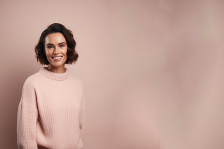 Portrait of a beautiful young woman in a pink sweater on a pink backgroundの素材