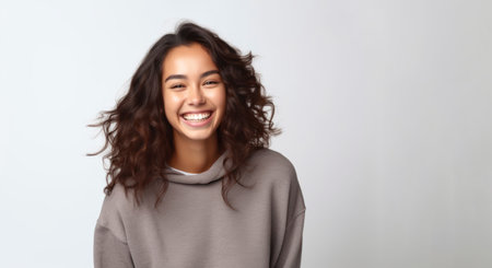 Beautiful young asian woman with curly hair smiling on white backgroundの素材