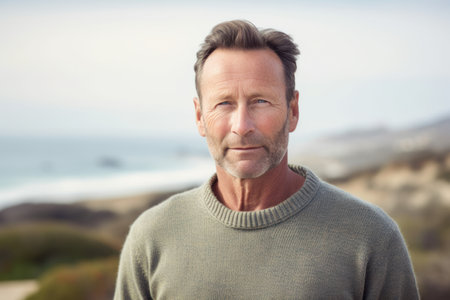 Portrait of smiling man looking at camera at beach on a sunny dayの素材