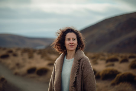 Portrait of a beautiful woman with curly hair in the middle of the desertの素材