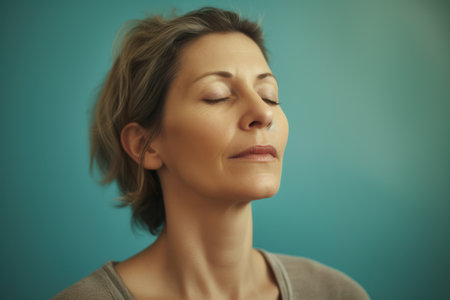 Portrait of a beautiful woman with closed eyes on a blue backgroundの素材
