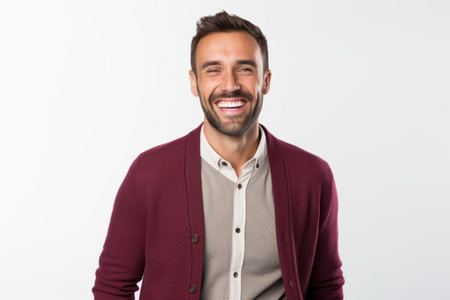 Portrait of a happy young man smiling at camera over white backgroundの素材