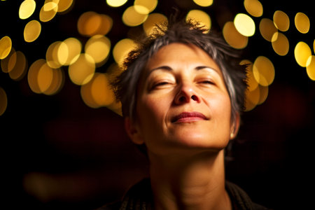 Portrait of a beautiful middle-aged woman with closed eyes on bokeh backgroundの素材