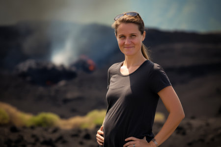 Portrait of a beautiful young woman standing in the middle of a volcanic landscapeの素材