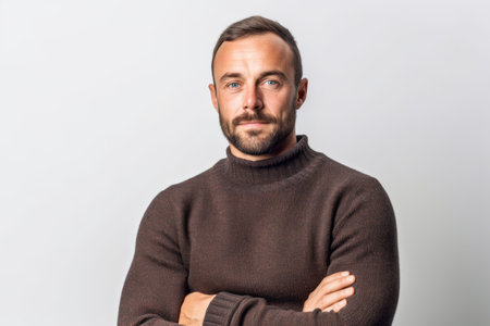 Portrait of a handsome bearded man in a brown sweater on a white backgroundの素材