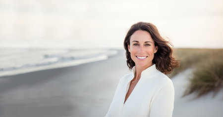 Portrait of a happy woman standing on the beach against white backgroundの素材