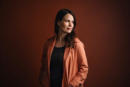 portrait of a beautiful young brunette woman in an orange coatの素材