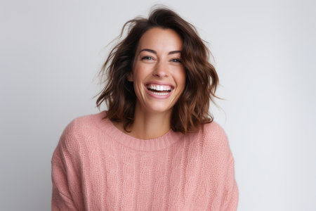 Portrait of a happy young woman laughing isolated on a white backgroundの素材