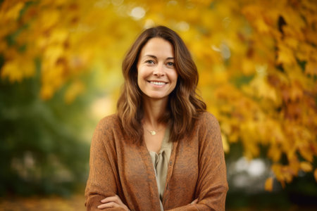 Portrait of a smiling young woman in an autumnal park.の素材