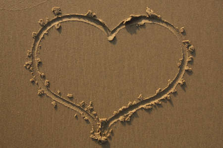 A heart drawn in the sand at the beach