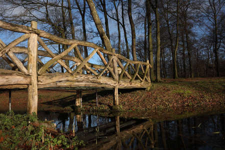 A local park with a wooden bridge over waterの写真素材