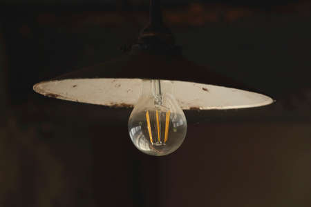A close-up of a lightbulb in an old workshop.