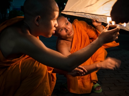 Buddhist Monks Lighting Up Hot Air Balloon at Loi Krathong 2013 Festivalのeditorial素材