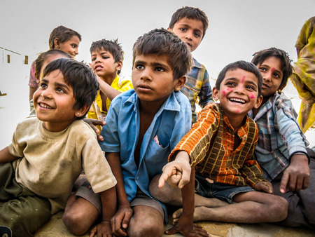 Happy Indian Children Sitting Out, Smiling, at Desert Village in Jaisalmer, Rajasthan, Indiaのeditorial素材