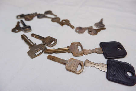 a pile of old and rusted keys lined up on a curve manner