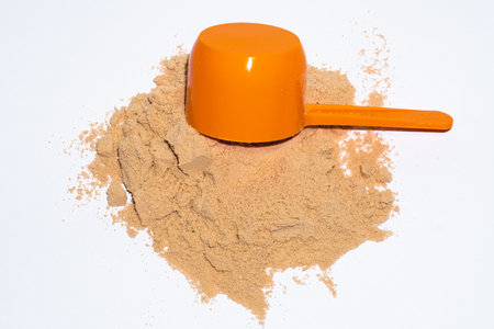 Protein powder with it measuring cup on top, on backgroundの写真素材