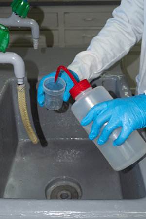 A person cleaning a plastic cup with distilled waterの写真素材