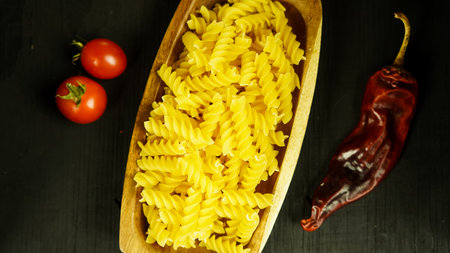 pasta in a dish dry appetizing spiral macaroni in the kitchen food preparationの写真素材