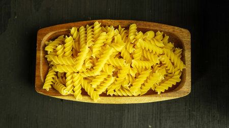pasta in a dish dry appetizing spiral macaroni in the kitchen food preparationの写真素材