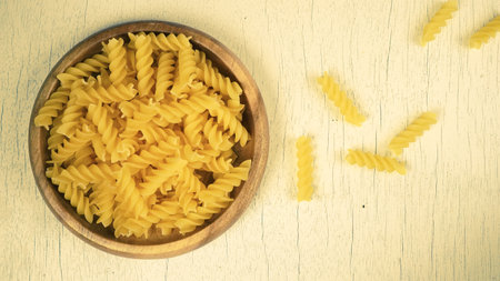 pasta in a dish dry appetizing spiral macaroni in the kitchen food preparationの写真素材