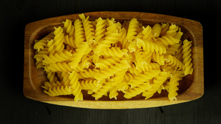 pasta in a dish dry appetizing spiral macaroni in the kitchen food preparationの写真素材