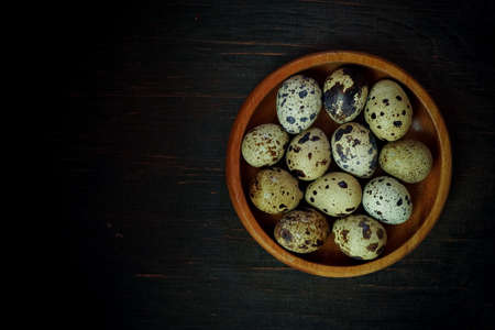 Fresh quail eggs close up on a wooden table small hard boiled eggs rustic top viewの写真素材