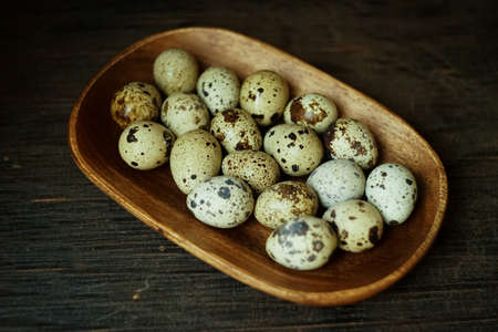 Fresh quail eggs close up on a wooden table small hard boiled eggs rustic top viewの写真素材