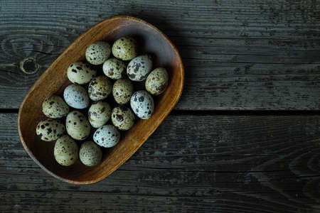 Fresh quail eggs close up on a wooden table small hard boiled eggs rustic top viewの写真素材