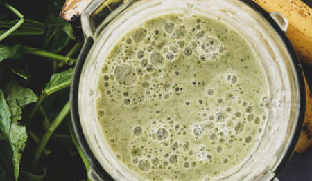 Healthy Green Smoothie in Glass on Grey Background Close Up