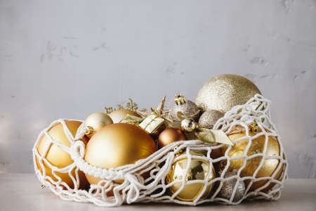 Christmas Decor Golden Baubles in String Bag on Table Minimal Design Copy Spaceの写真素材
