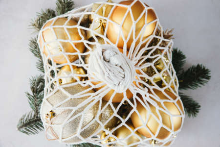 Christmas Decor Golden Baubles in String Bag on Table Top View Close Upの写真素材
